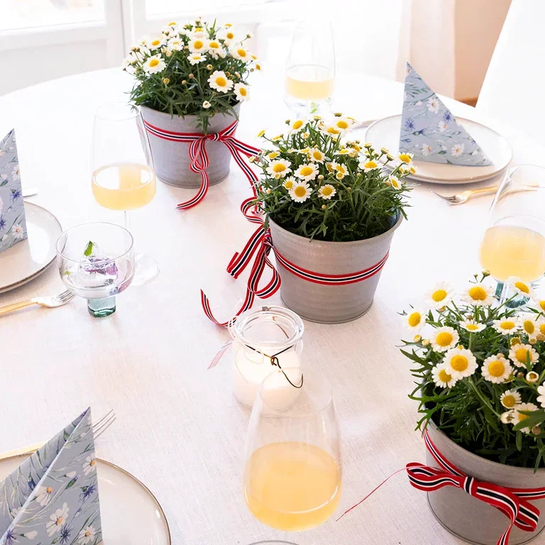 Pynt bordet til 17. mai med blomster og dekorasjoner i rødt, hvitt og blått